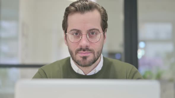 Close Up of Young Businessman with Laptop Showing Thumbs Down