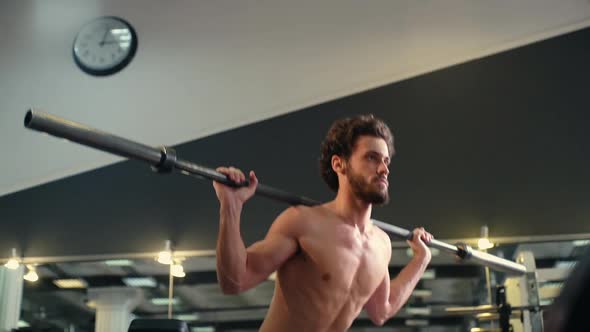 Handsome Bearded Young Man Squatting Using Heavy Barbell During Workout Training