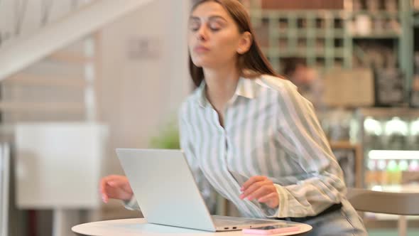 Young Latin Woman Coming Back and Working on Laptop in Cafe 