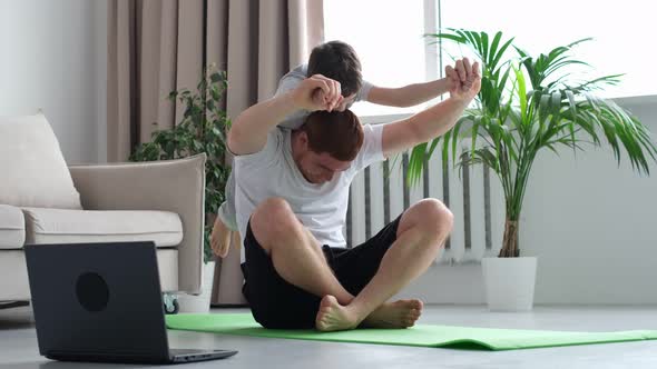 Dad Doing Morning Exercises While Active Energetic Child Son Playing
