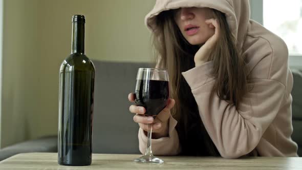 Unkempt Woman Drinking Wine Alone