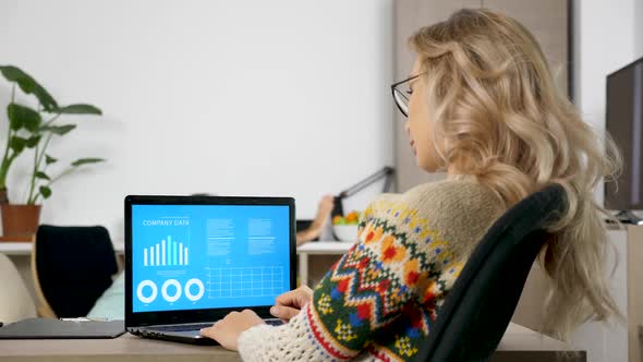 Woman Studying Company Data Analysis on Animated Chart While Her Husband Is Making a Lot of Noise in