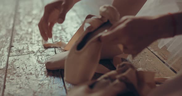 Ballerina Wearing Pointe Shoes on Her Feet Straightens the Tape