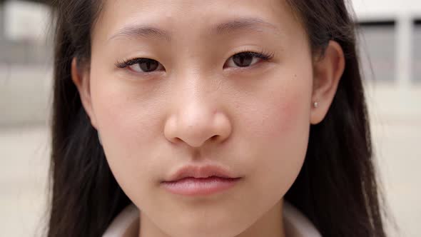 Close Up Shot of Chinese Teenage Girl Looking at Serious Camera