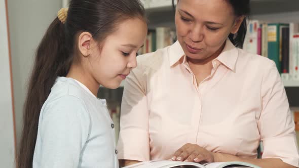 Mother and Daughter Choosing Books at the Library or Bookstore