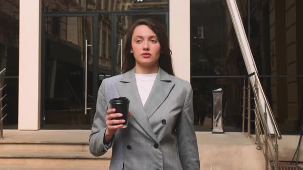 Pretty Caucasian Woman Drinking Coffee on the Street