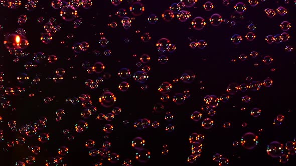 Blue, Red and Orange Soap Bubbles on Black, Background, Slow Motion