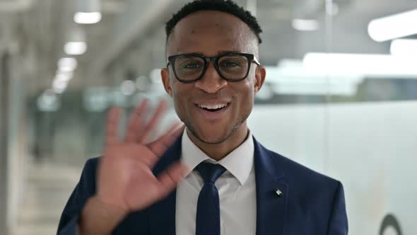 Portrait of Cheerful African Businessman Waving at the Camera 