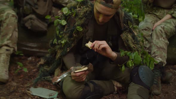 Servicemen Resting in Halt Preparing MRE Rations Eating in Forest