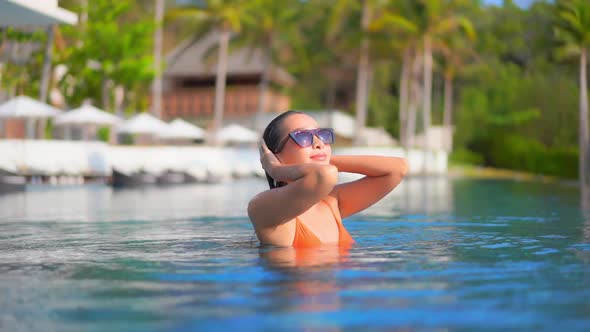 Young asian woman enjoy around outdoor swimming pool for leisure