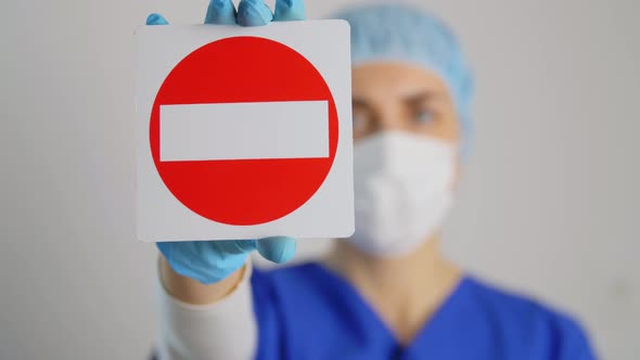 Doctor or Nurse in Face Mask Showing Stop Sign