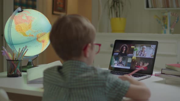 Preschool Boy Learning Online with School Teacher and Pupils on Laptop Screen