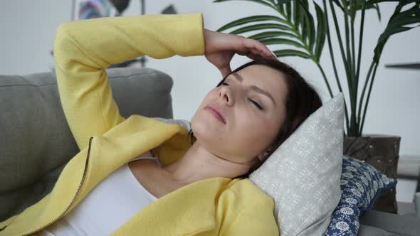 Headache, Tense Woman Laying on Sofa at Home