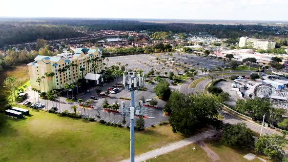 Telecommunication tower with 5G cellular network antenna on city background, aerial orbit view