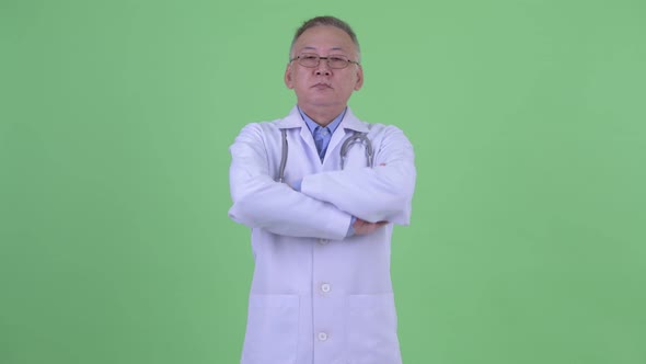 Happy Mature Japanese Man Doctor Smiling with Arms Crossed