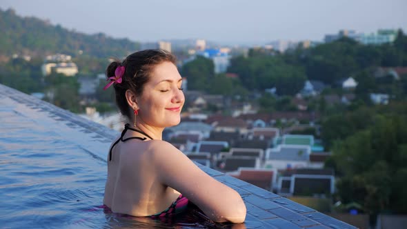 Attractive Brunette Smiles Cheerfully Chilling in Pool