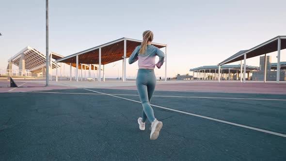 Young Athletic Woman Outdoors Runner Run Along Modern Metal Constructions