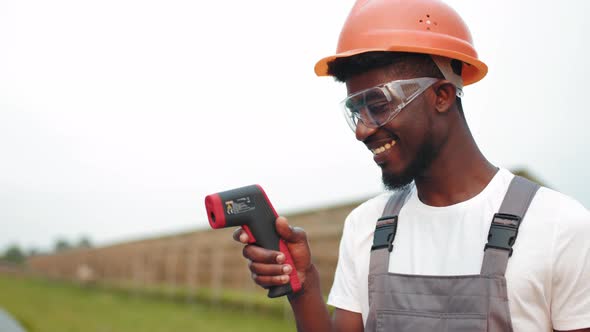 Engineer in Uniform Measuring Temperature of Solar Panels