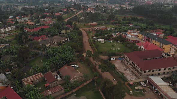 Aerial drone shot following motorbikes riding a town road of Kampala, Uganda, Africa.