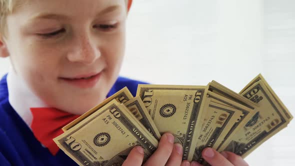 Boy as executive counting the bank notes in office