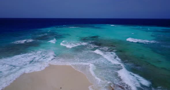 Luxury flying tourism shot of a paradise sunny white sand beach and blue sea background in hi res 4K