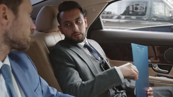Mixed-Race Businessman Talking to Partner in Car