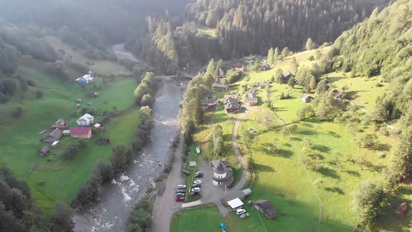 Aerial View of the Carpathian Mountain Valley with Green Meadows and Trees