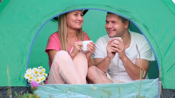 A Loving Couple is Resting in the Mountains They are Sitting in a Tent and Talking