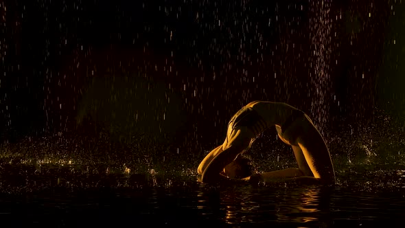 Practice Yoga in Bridge Pose. The Yellow Light Falls Softly on the Wet Body of a Young Attractive