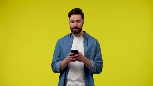 Portrait of a Bearded Man Checking His Phone and Celebrating