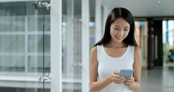 Student walking in the campus and using mobile phone 