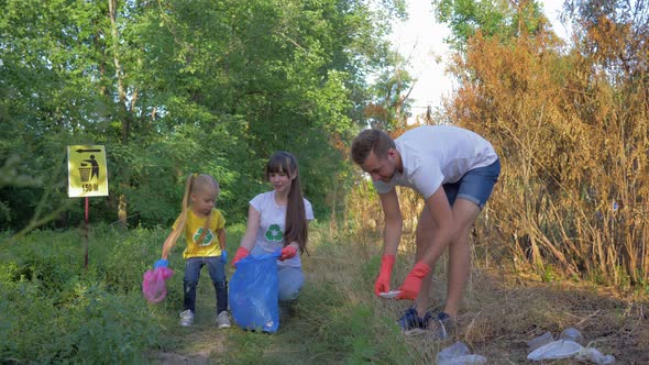 Young Volunteer Male and Female with Child Girl Cares About Ecology Environmental and Collect