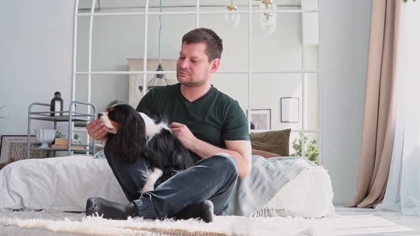 In a Stylish Home Apartment A Happy Man Plays with His Dog a Great Pet