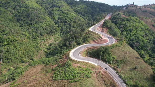 Aerial view of mountain road through tropical forest in countryside of Asia by drone