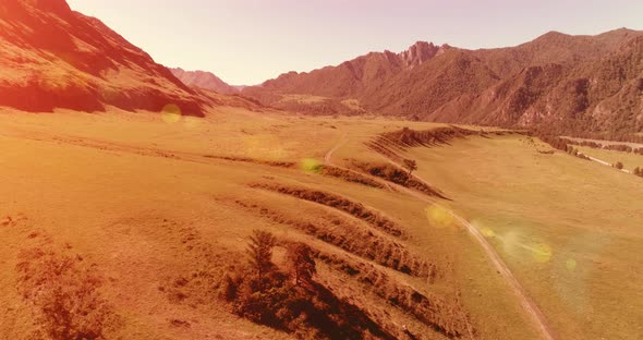 Aerial Rural Mountain Road and Meadow at Sunny Summer Morning. Asphalt Highway and River.