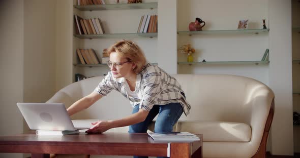 Woman Look at Laptop Screen Sit on Sofa Wide Shot Footage