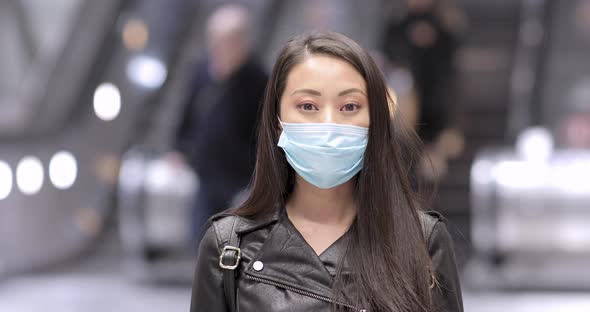 Chinese woman in London wearing face mask to protect from covid 19 coronaviru