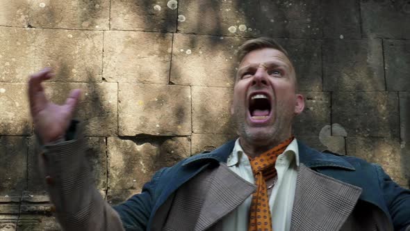 Medium Portrait Shot of Man Shouting with the Bayon Temple Ruins in Background alt