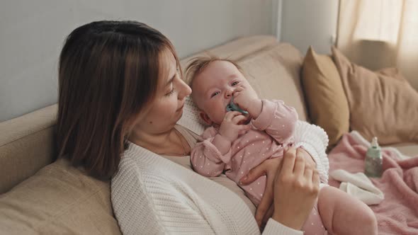 Baby with Pacifier in Arms of Mother