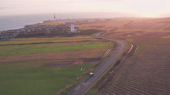 Cars driving towards Portland Bill Lighthouse, Dorset, England. Aerial drone view