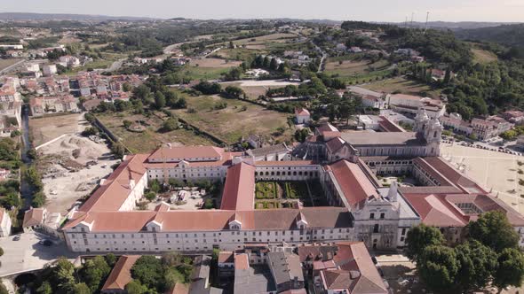 Aerial pan shot of the side entrance of Alcobaça monastery complex in historic city of Portugal.