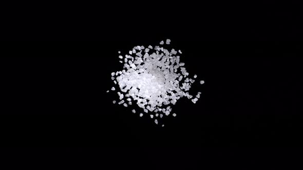 Sea salt exploding against black background. Slow Motion.