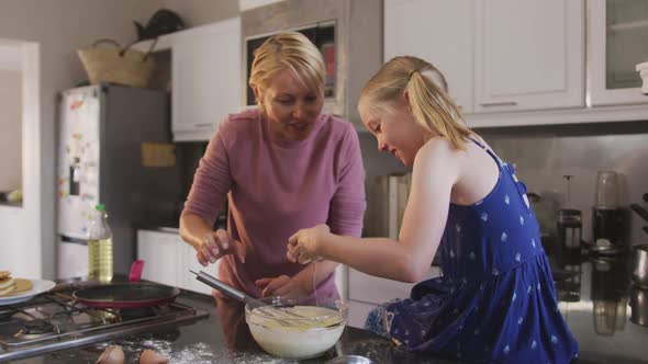 Side view of Caucasian woman cooking with her daughter at home