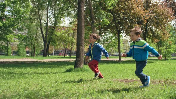 Excited Little Friends Running through Park