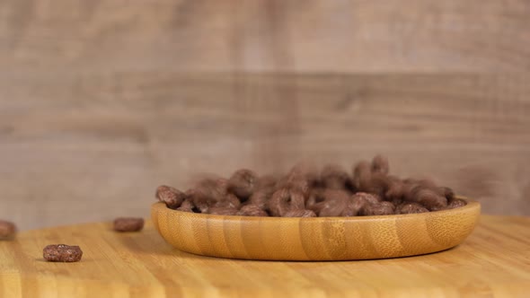 Chocolate rings falling in wooden container.  