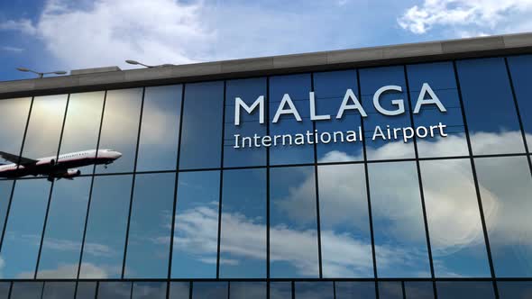 Airplane landing at Malaga Spain airport mirrored in terminal