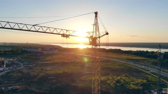 Yellow Crane at a Sunset, Close Up. Tower Crane at a Construction Site alt