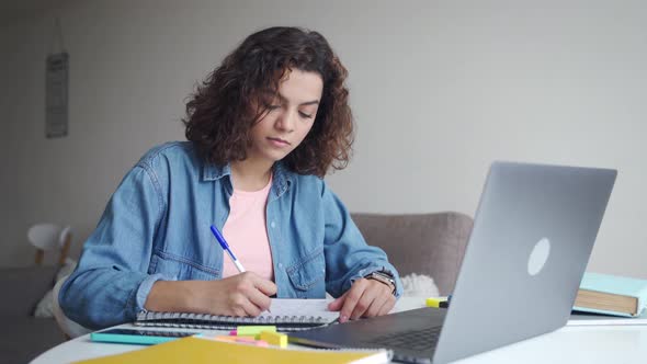 Concentrated Attractive Hispanic Student Studying Online on Laptop Computer