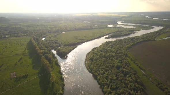 Aerial view of a big river with green banks.