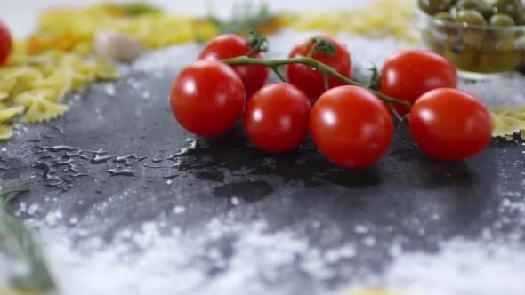 Wet Tomatoes on Twig Being Dropped on Kitchen Table